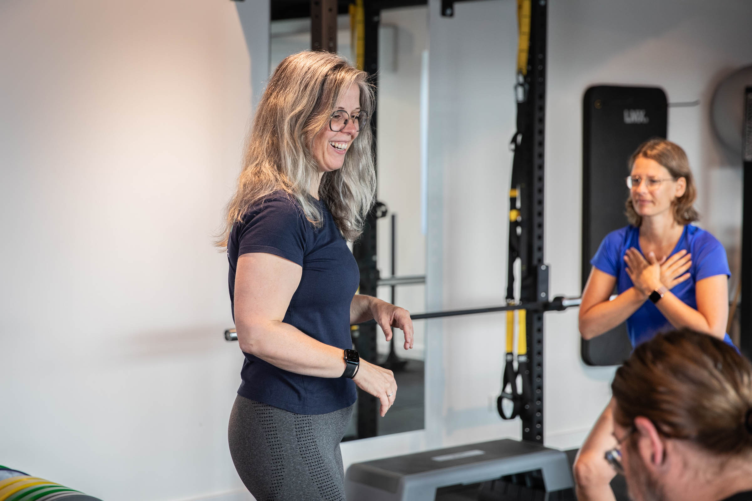 Fit Beyond Form Lachende personal trainer die mensen aan het trainen is bij Fit Beyond Form