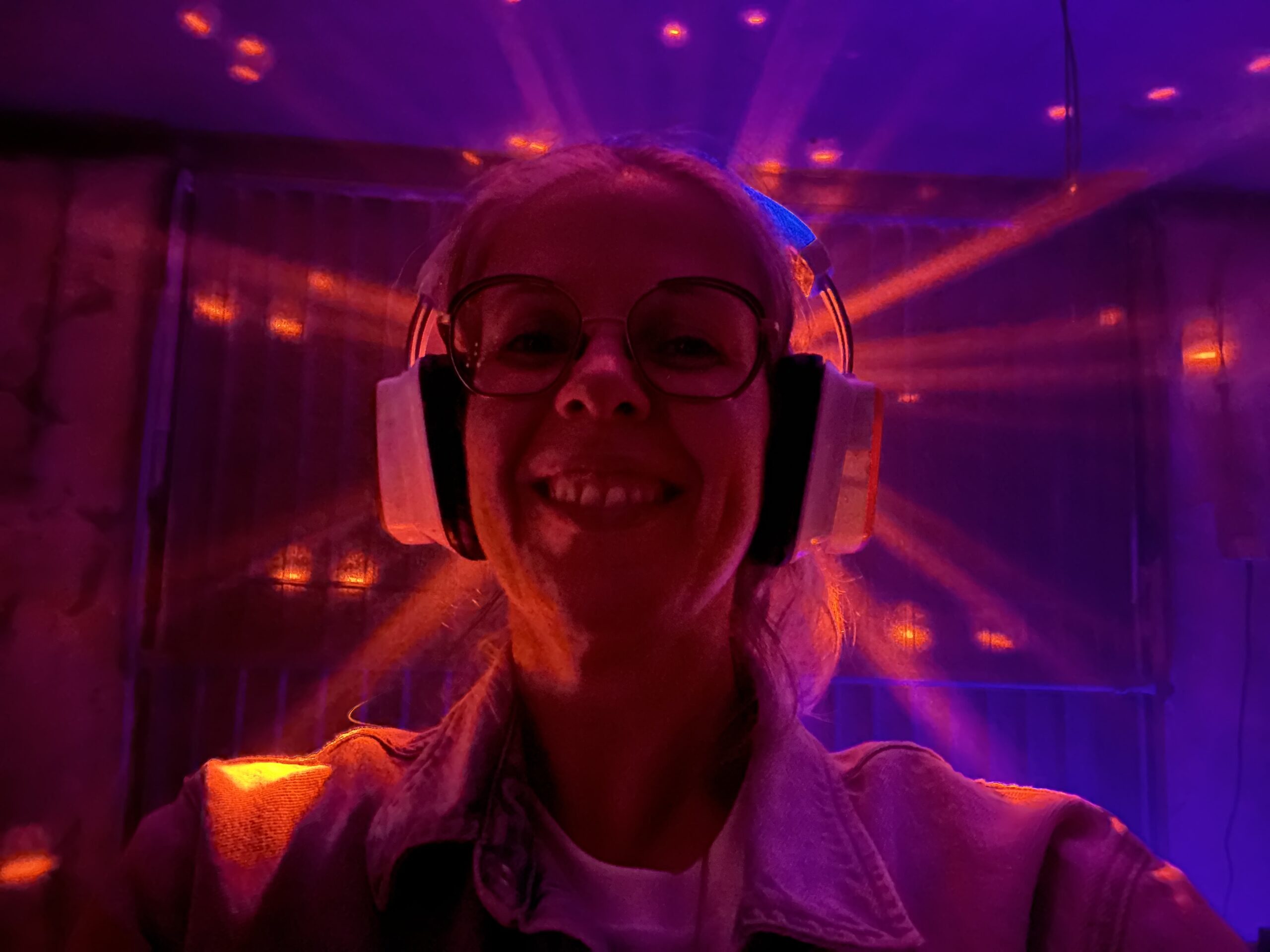 Vrouw met koptelefoon op die een lichtstraal achter haar hoofd heeft